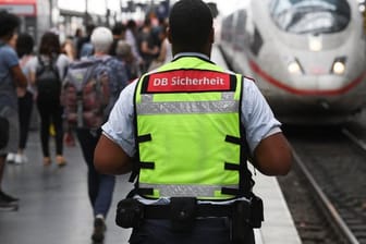 Ein Mitarbeiter der DB Sicherheit steht am Gleis 7 des Frankfurter Hauptbahnhofs, in den ein ICE einfährt.