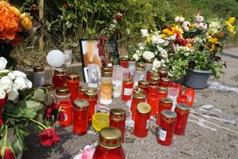 Kerzen und Blumen stehen am Tatort um ein Porträt des dort getöteten Mannes herum.