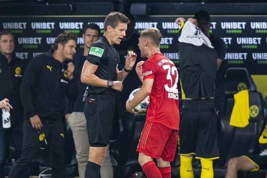 Joshua Kimmich (r) diskutiert nach der Gelben Karte mit Schiedsrichter Daniel Siebert, der ihm für das Foul Sancho nur verwarnte.