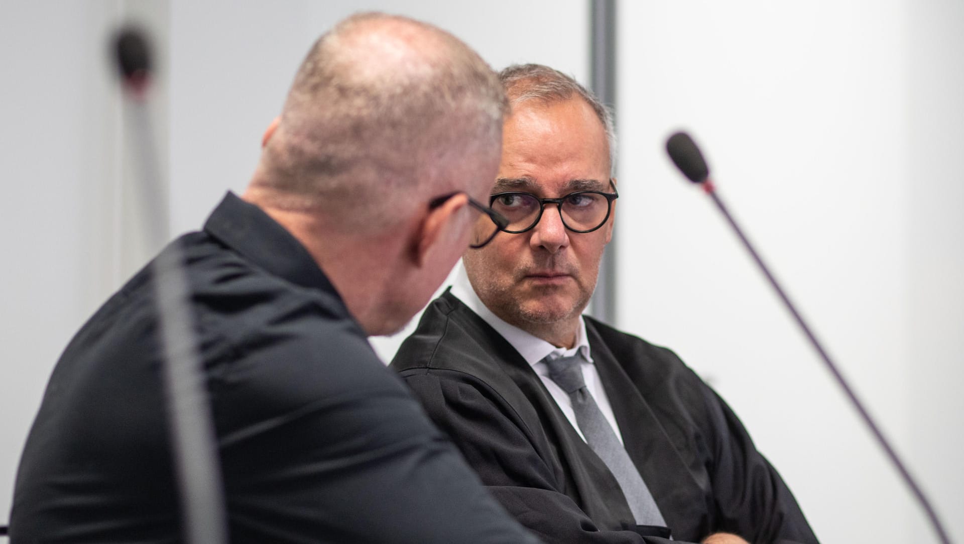 Der Verteidiger Christoph Jahrsdörfer (r) spricht im Aschaffenburger Landgericht mit dem 44-jährigen Angeklagten (l), der sich wegen verschiedenster Delikte verantworten muss.