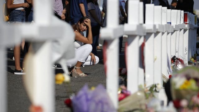 Eine Frau kniet in El Paso neben einem provisorischen Denkmal für die Opfer des Massakers. Eine Frau kniet in El Paso neben einem provisorischen Denkmal für die Opfer des Massakers.