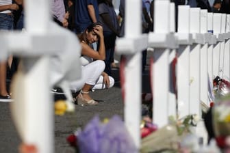 Eine Frau kniet in El Paso neben einem provisorischen Denkmal für die Opfer des Massakers.