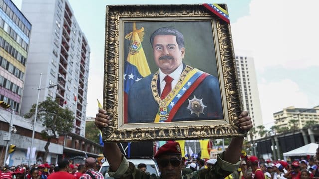 Ein Anhänger von Maduro mit einem Porträt des venezolanischen Präsidenten.