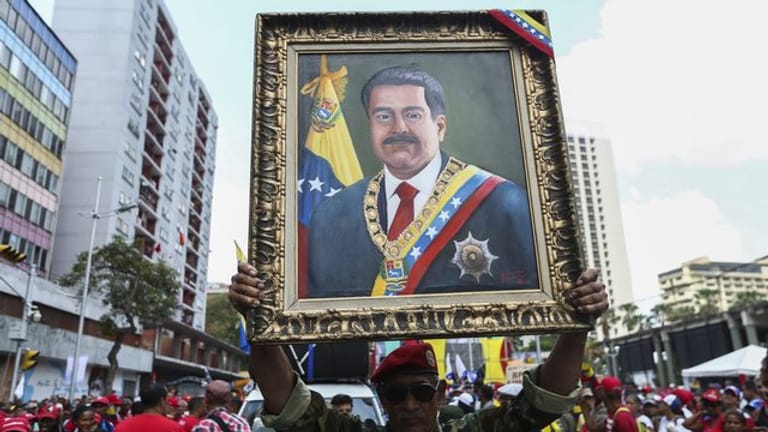 Ein Anhänger von Maduro mit einem Porträt des venezolanischen Präsidenten.
