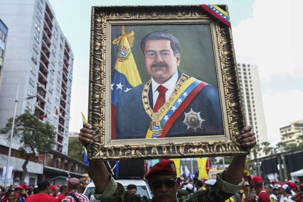 Ein Anhänger von Maduro mit einem Porträt des venezolanischen Präsidenten.
