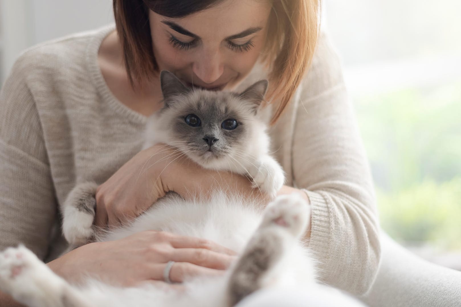 Frau mit Katze: Die Katze braucht das Streicheln nicht. Es ist der Mensch, der dem Kraulen schwer widerstehen kann. Das hat einen bestimmten Grund.