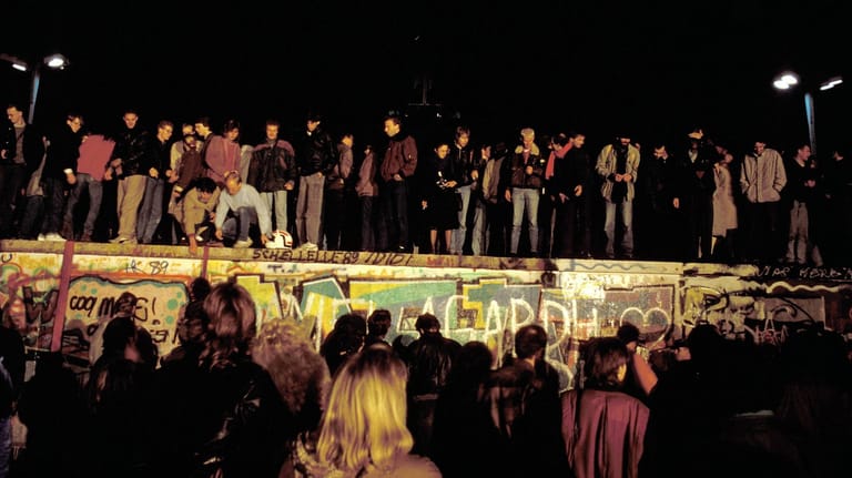 Menschen stehen auf der Berliner Mauer: Im Rückblick wird deutlich, dass bei der Wiedervereinigung vieles hätte anders laufen können.