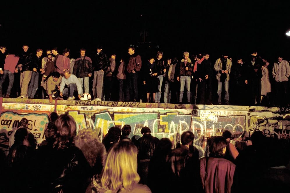 Menschen stehen auf der Berliner Mauer: Im Rückblick wird deutlich, dass bei der Wiedervereinigung vieles hätte anders laufen können.