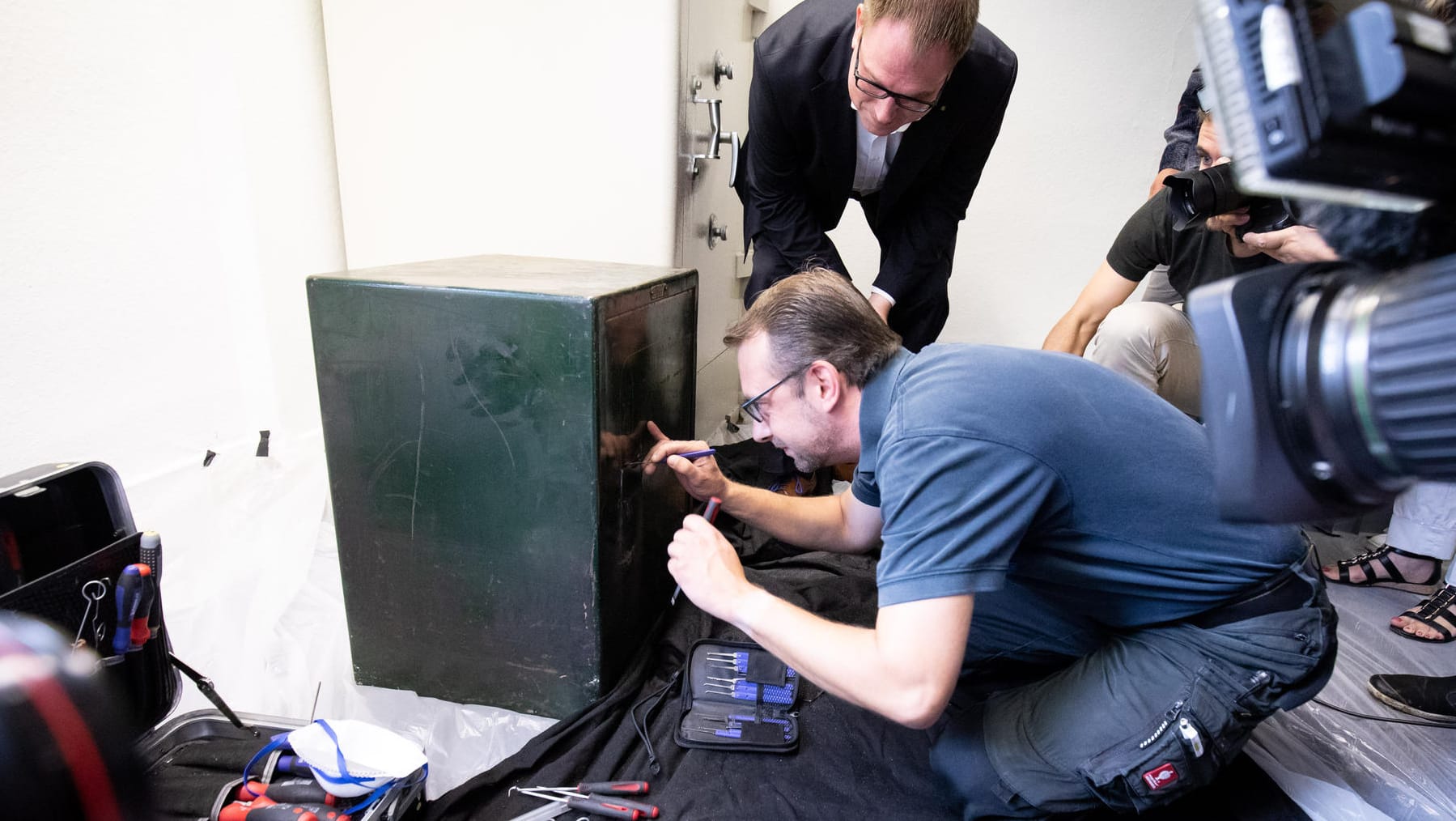 Schatzsuche im Lübecker Rathaus: Unter den Augen von Bürgermeister Jan Lindenau (SPD, hinten) und etlichen Kameras öffnet Sicherheitstechniker Sebastian Hahn den kleineren der zwei Tresore.