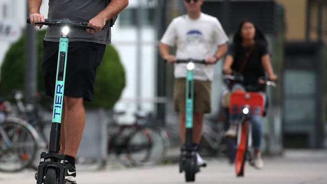 Touristen fahren mit E-Tretrollern durch Köln.