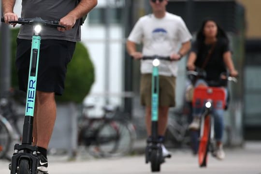 Touristen fahren mit E-Tretrollern durch Köln.