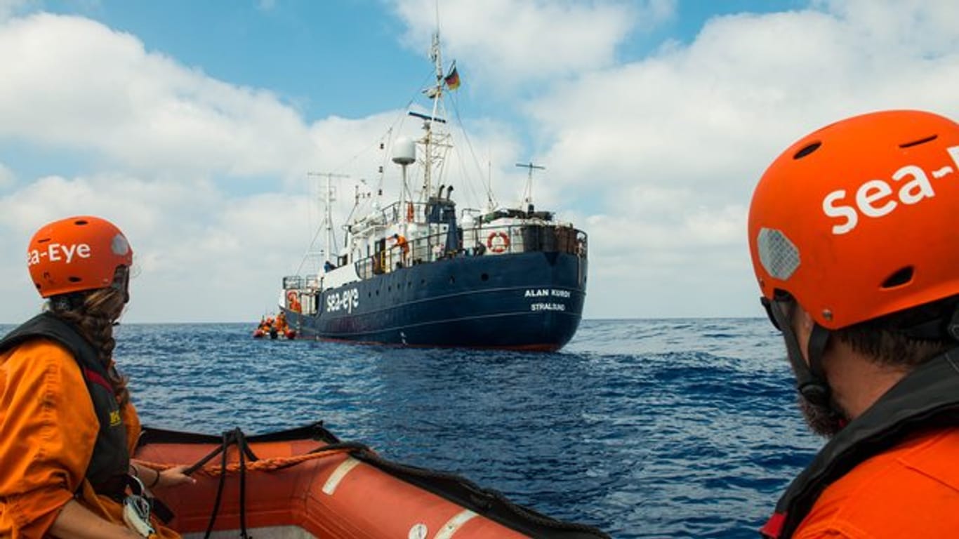 Zwei Seenotretter vor dem Rettungsschiff "Alan Kurdi".
