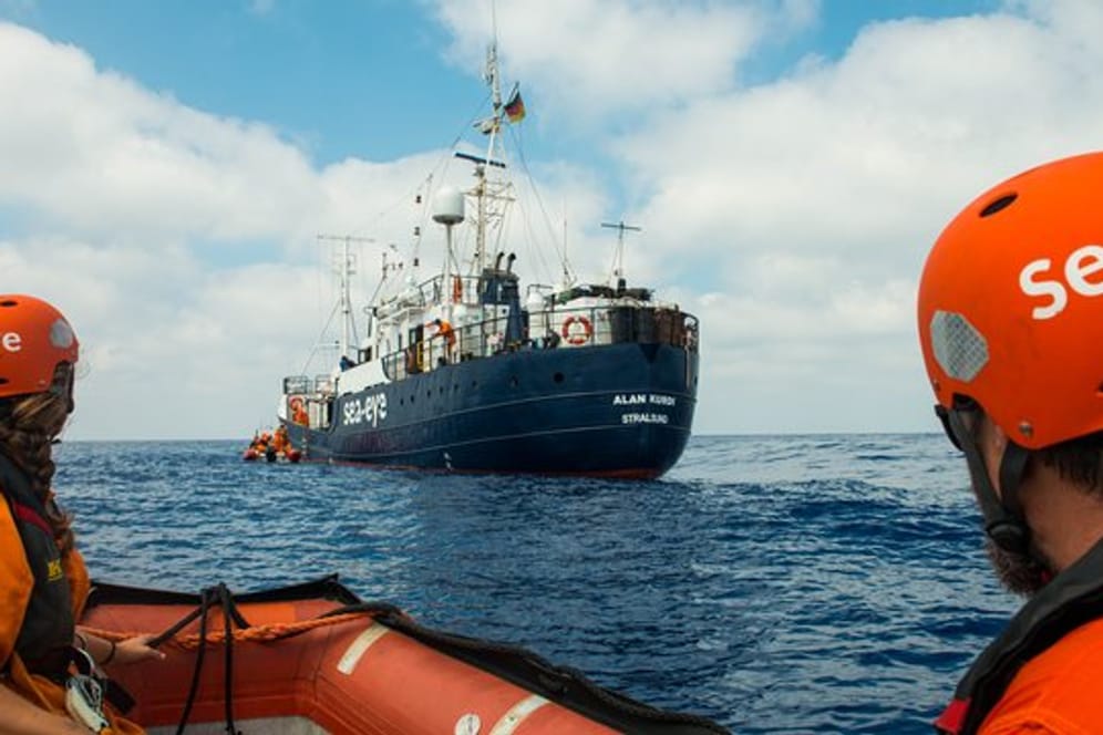 Zwei Seenotretter vor dem Rettungsschiff "Alan Kurdi".