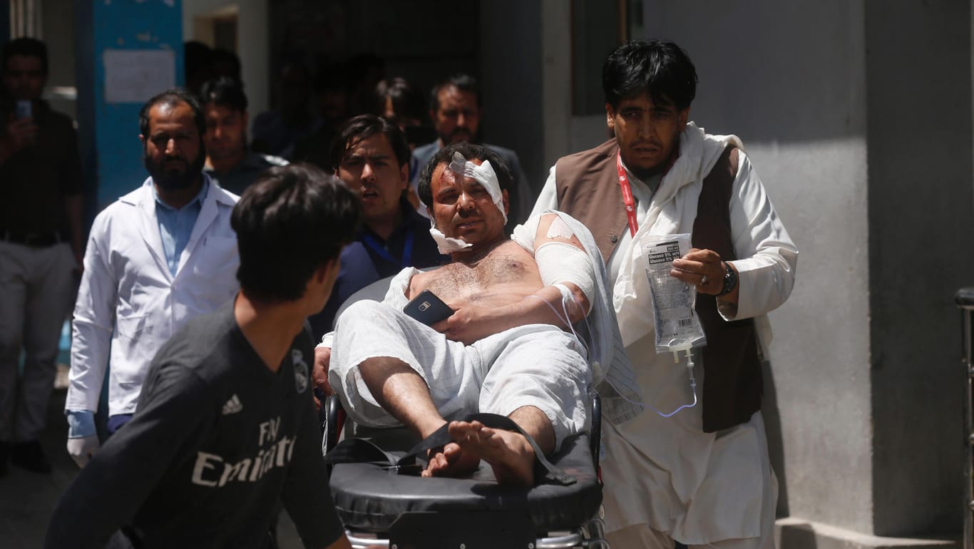 Nach dem Anschlag in Kabul: Helfer bringen einen Verletzten zu einem Krankenwagen.