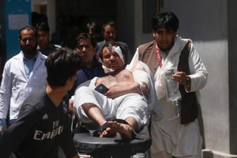 Nach dem Anschlag in Kabul: Helfer bringen einen Verletzten zu einem Krankenwagen.
