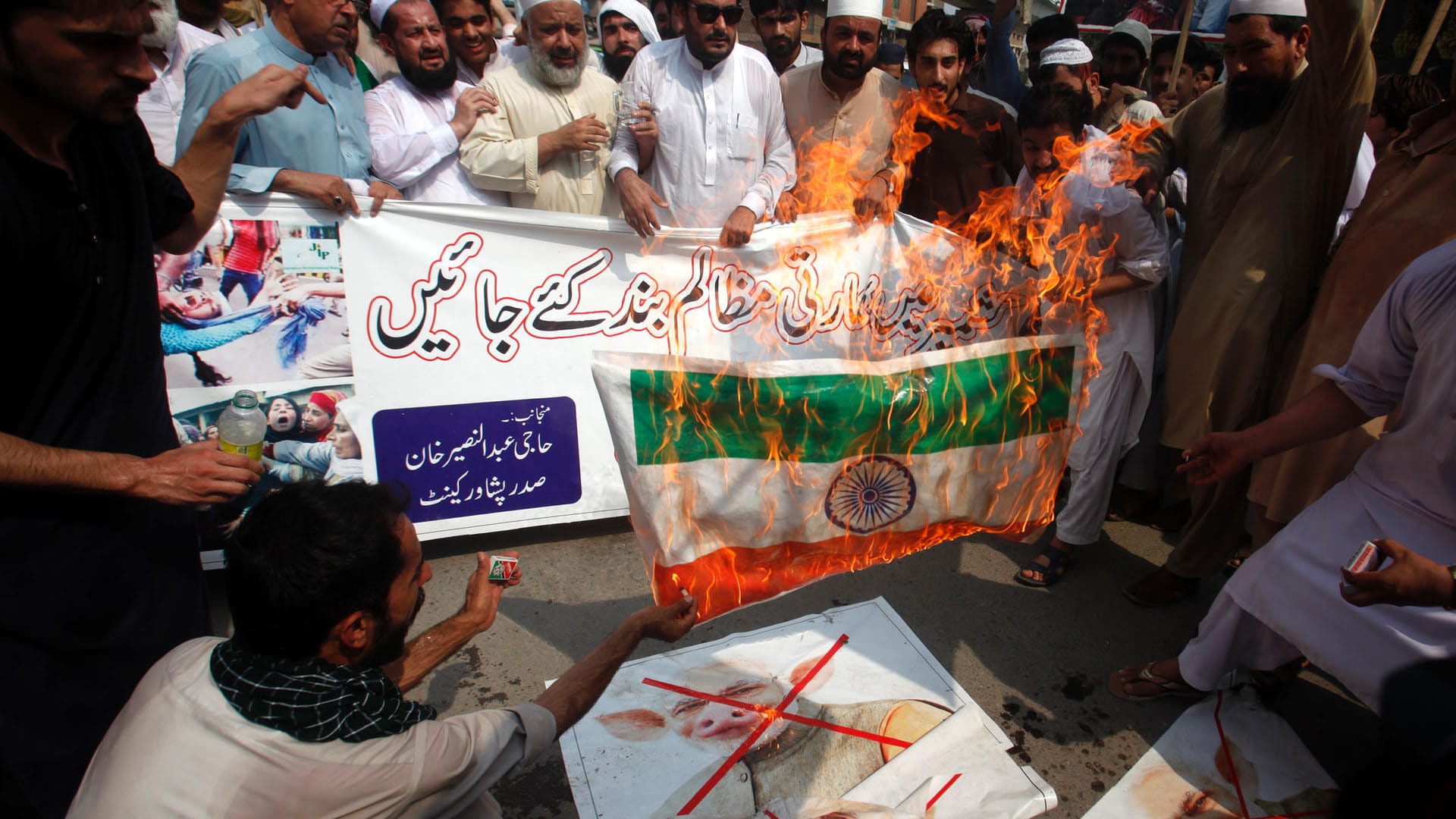 Angespannte Lage: Radikale Demonstranten verbrennen die indische Fahne und ein Poster, das Indiens Premier Narendra Mody als Schwein zeigt, bei einer Kundgebung am Montag in Peshawar (Pakistan).