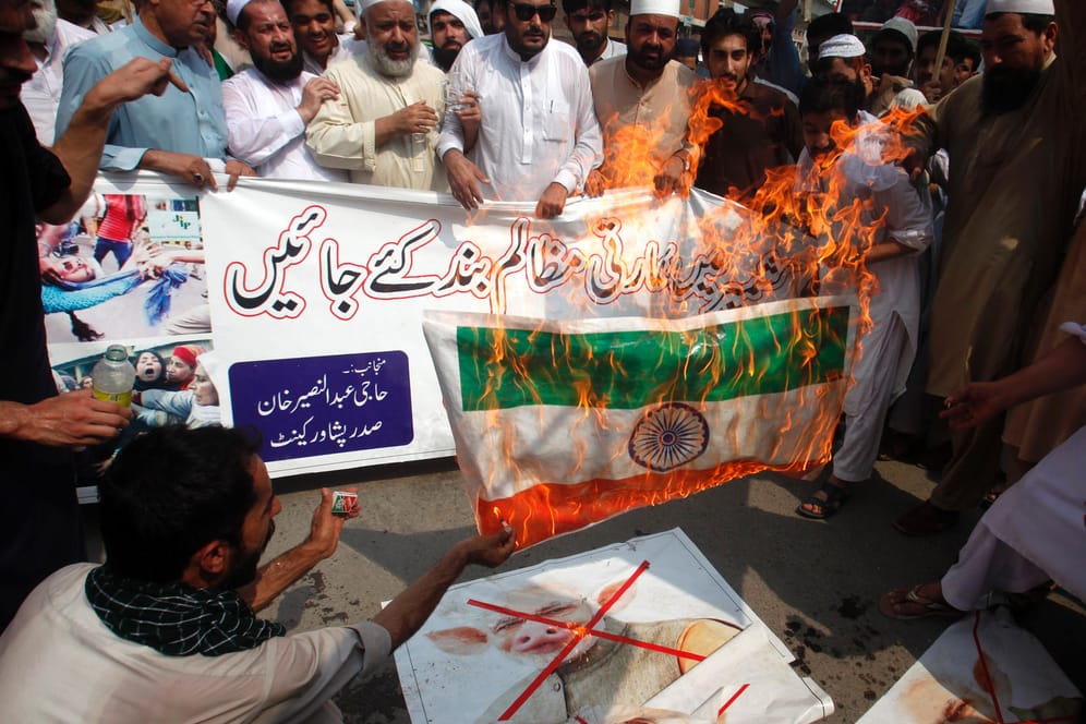 Angespannte Lage: Radikale Demonstranten verbrennen die indische Fahne und ein Poster, das Indiens Premier Narendra Mody als Schwein zeigt, bei einer Kundgebung am Montag in Peshawar (Pakistan).