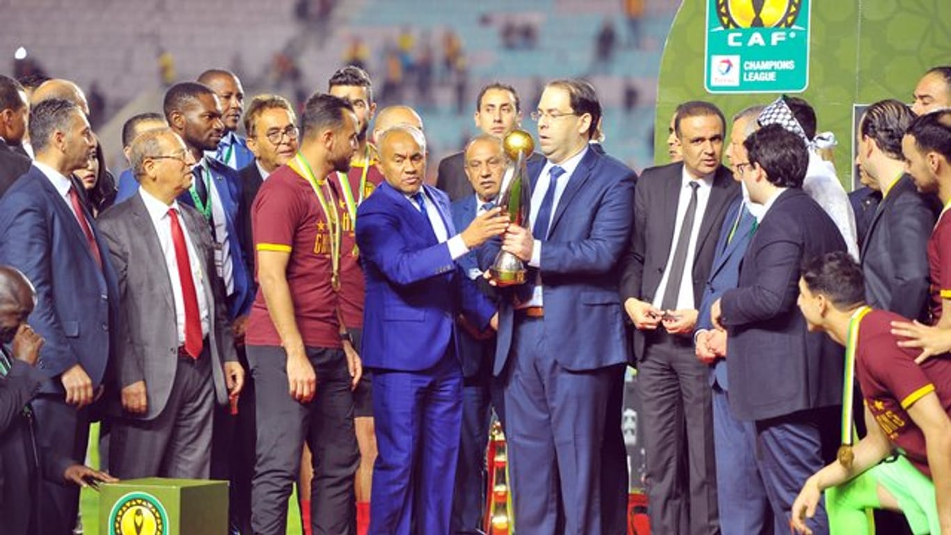 Tunesiens Premierminister Youssef Chahed (M/r) und CAF-Präsident Ahmad Ahmad überreichen den Pokal an Moez Ben Cherifia, Kapitän von Esperance Tunis.