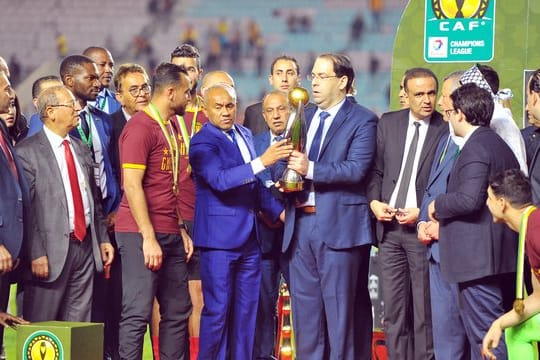 Tunesiens Premierminister Youssef Chahed (M/r) und CAF-Präsident Ahmad Ahmad überreichen den Pokal an Moez Ben Cherifia, Kapitän von Esperance Tunis.