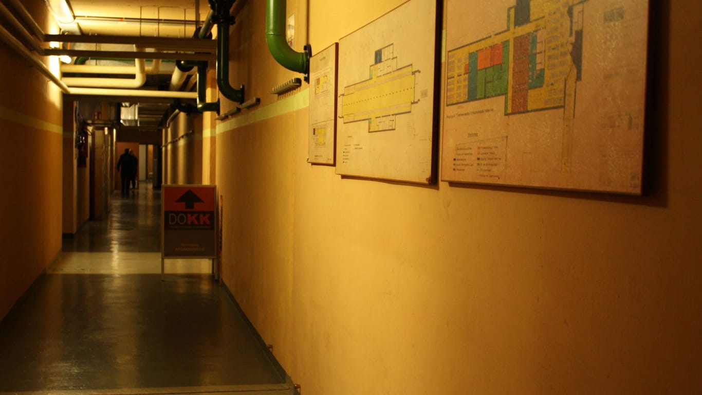 Ein Gang mit Lageplänen an der Wand: Durch diesen Gang gelangt man in das Innere des Bunkers.