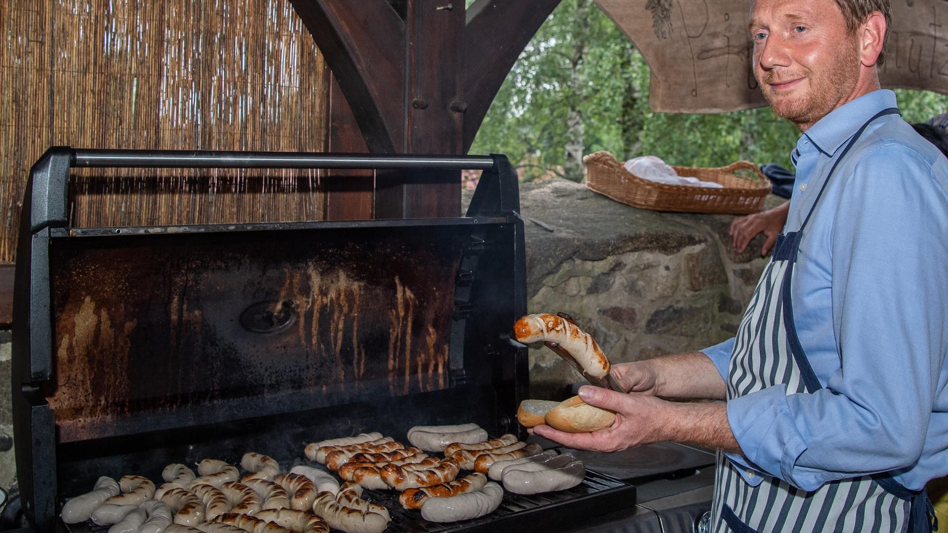 Kretschmer grillt zum Auftakt seiner Sommertour in Arnsdorf Bratwürste: Wenn es volksnah werden soll, gibt es oft Wurst.