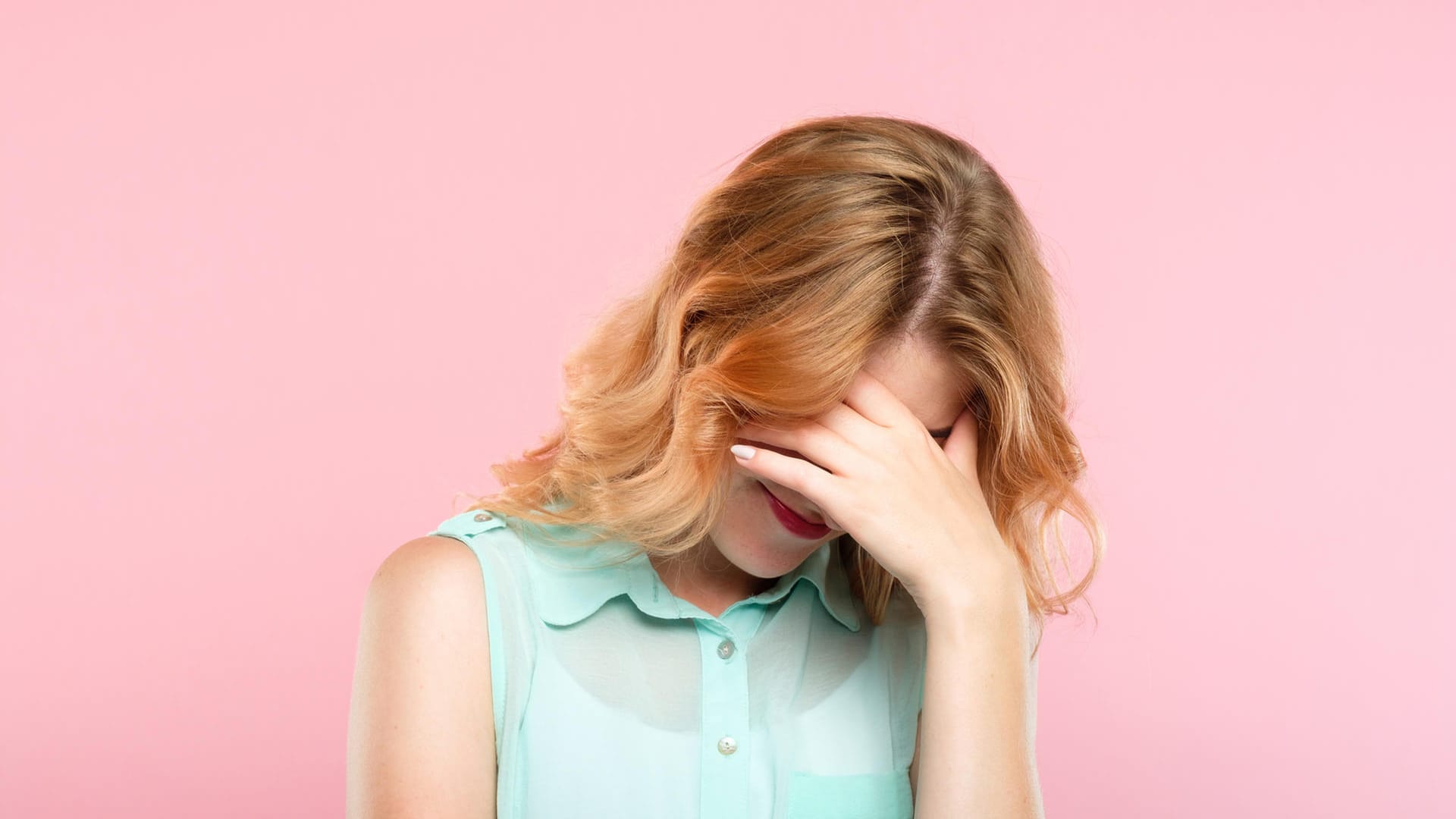 Eine Frau hält sich die Hände vor das Gesicht: Schamgefühl hat etwas mit Empathie zu tun.