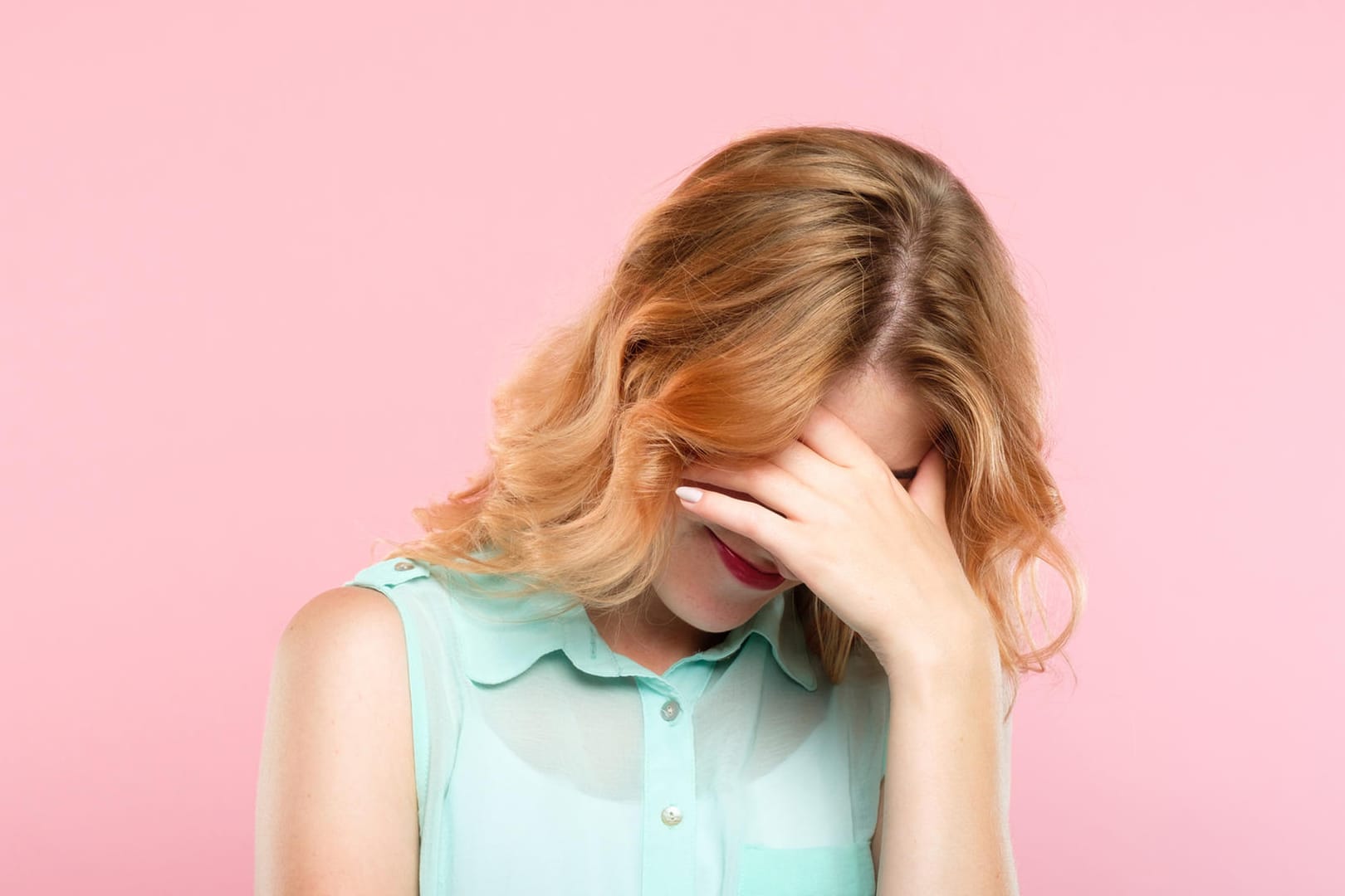 Eine Frau hält sich die Hände vor das Gesicht: Schamgefühl hat etwas mit Empathie zu tun.