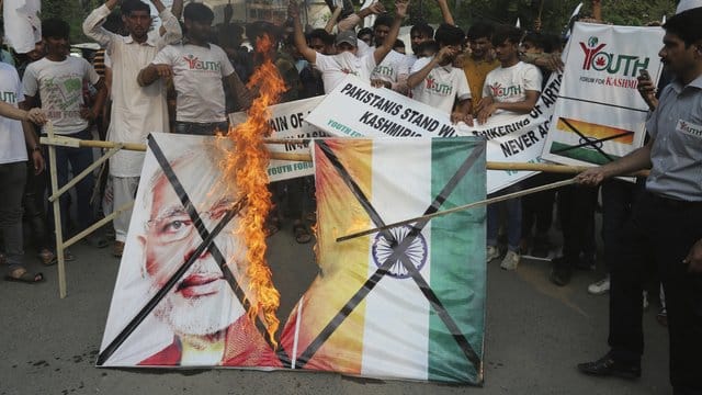Pakistanische Demonstranten verbrennen bei einer Kundgebung in Lahore eine Fahne mit dem Bild des indischen Premierministers Modi. Pakistanische Demonstranten verbrennen bei einer Kundgebung in Lahore eine Fahne mit dem Bild des indischen Premierministers Modi.