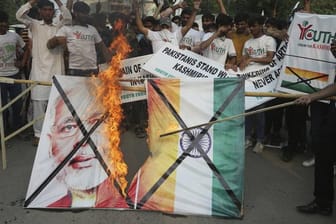 Pakistanische Demonstranten verbrennen bei einer Kundgebung in Lahore eine Fahne mit dem Bild des indischen Premierministers Modi.