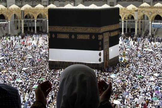 Tausende Pilger gehen um das würfelförmige Gebäude der Kaaba im Hof der Großen Moschee von Mekka herum.