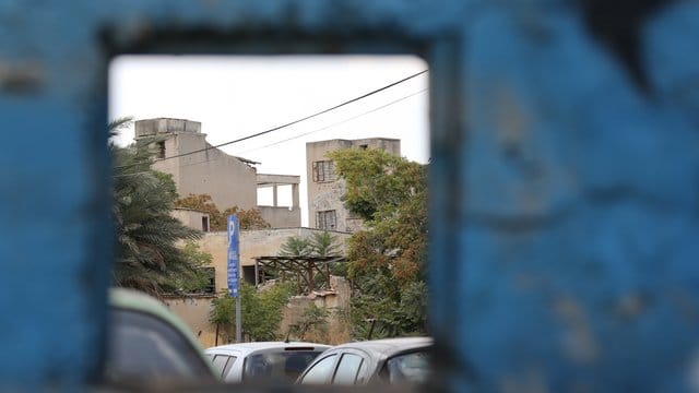 Durch eine Öffnung in einer Mauer ist der türkische Teil der geteilten Stadt zu sehen. Durch eine Öffnung in einer Mauer ist der türkische Teil der geteilten Stadt zu sehen.