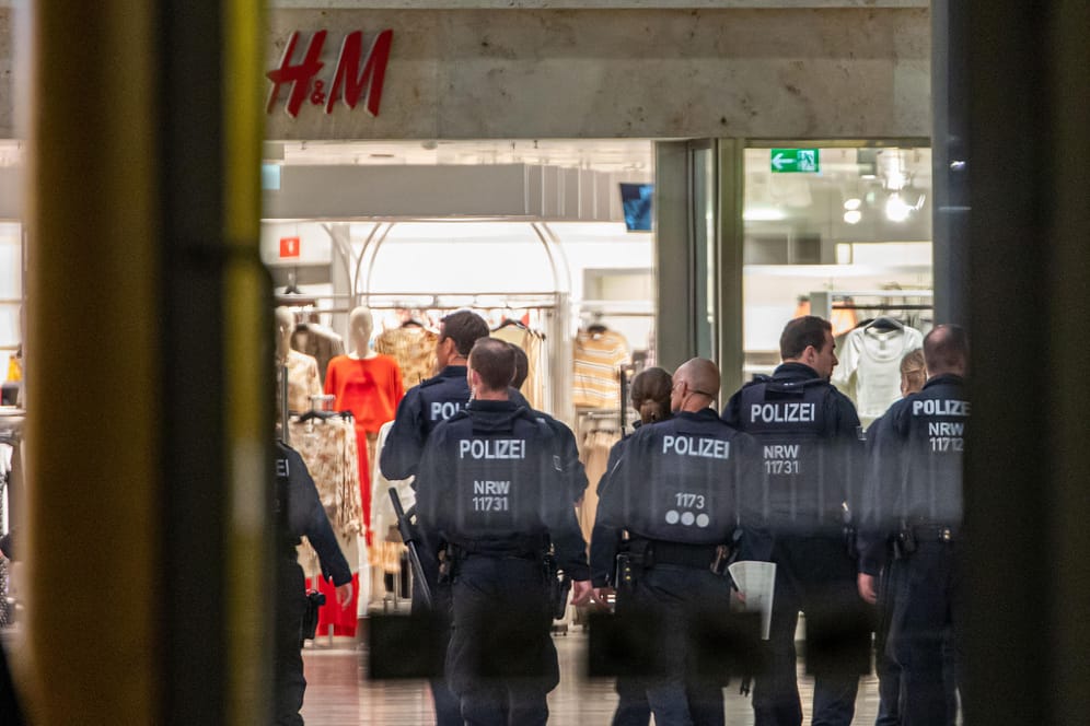 Polizeibeamte gehen durch ein Einkaufszentrum in Duisburg