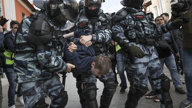 Polizisten nehmen einen Demonstranten am Rande eines Protestes für faire und freie Wahlen fest.