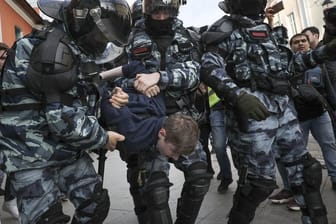 Polizisten nehmen einen Demonstranten am Rande eines Protestes für faire und freie Wahlen fest.