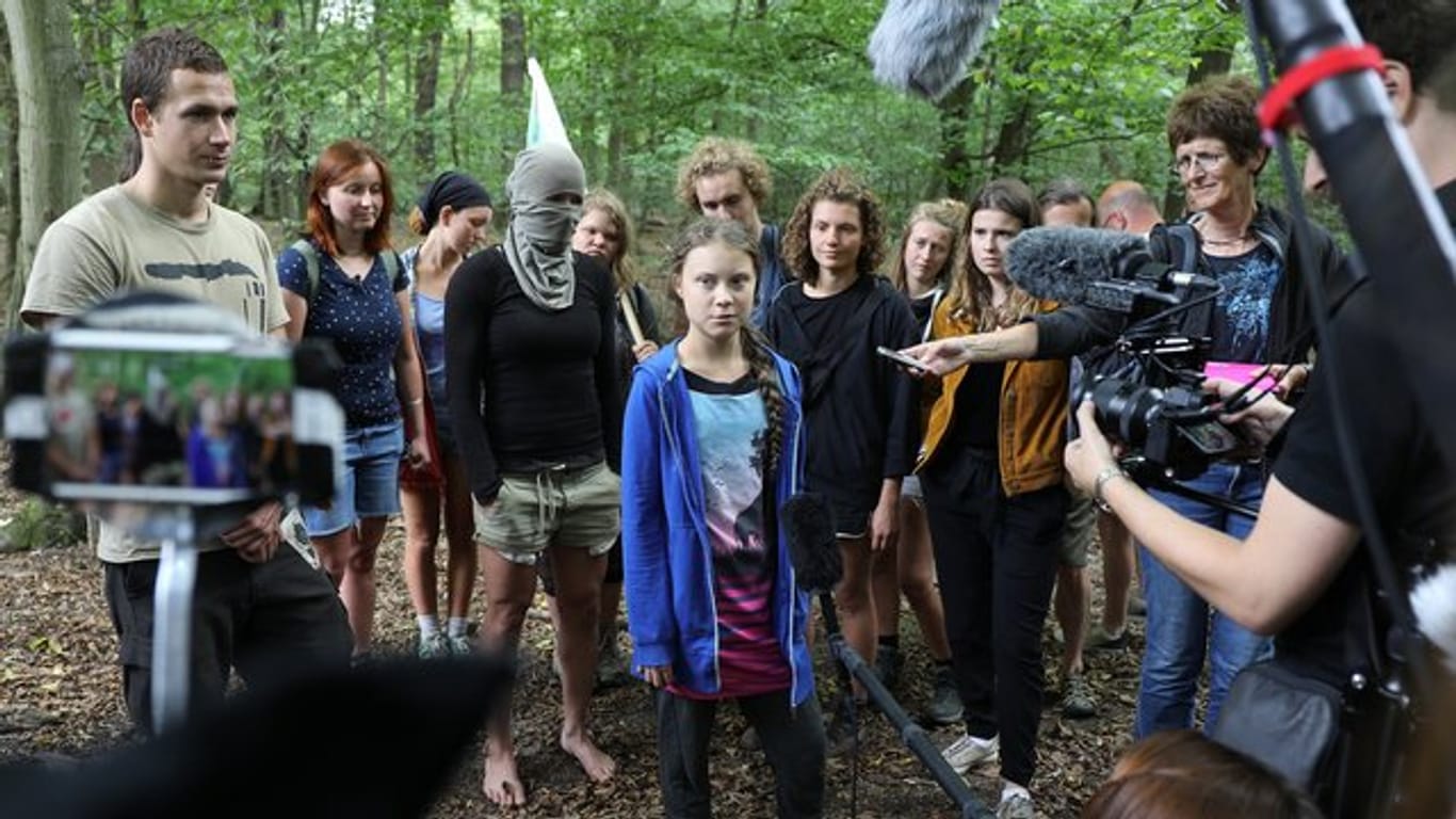 Greta Thunberg (M), Klimaschutzaktivistin, steht mit Aktivisten im Hambacher Forst.