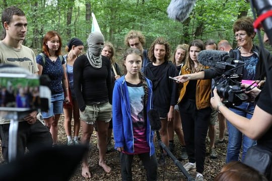 Greta Thunberg (M), Klimaschutzaktivistin, steht mit Aktivisten im Hambacher Forst.