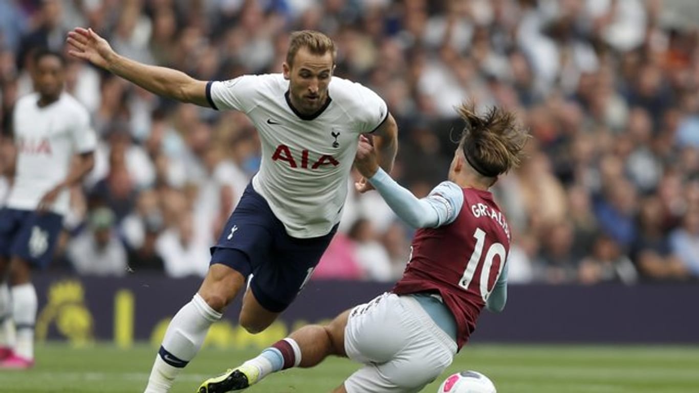 Tottenhams Harry Kane (l) kämpft mit Aston Villas Jack Grealish um den Ball.