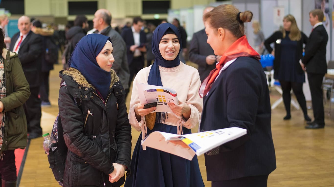 Zwei Frauen informieren sich auf einer Jobmesse: Über die Hälfte der Migranten aus der Türkei und dem Iran hat bereits eine Hochschule besucht.