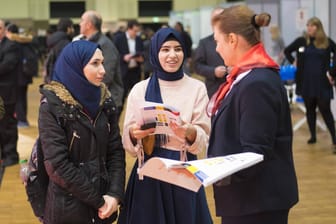 Zwei Frauen informieren sich auf einer Jobmesse: Über die Hälfte der Migranten aus der Türkei und dem Iran hat bereits eine Hochschule besucht.