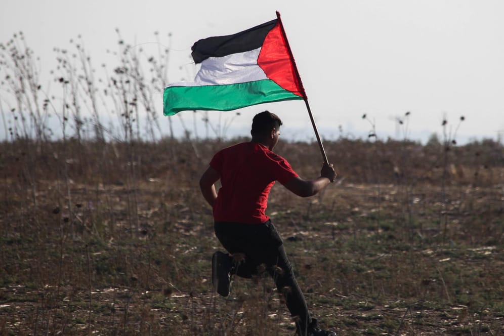 Ein Mann läuft am Gazastreifen mit einer palästinensischen Flagge: Israelische Soldaten haben einen Palästinenser erschossen. (Symbolbild)
