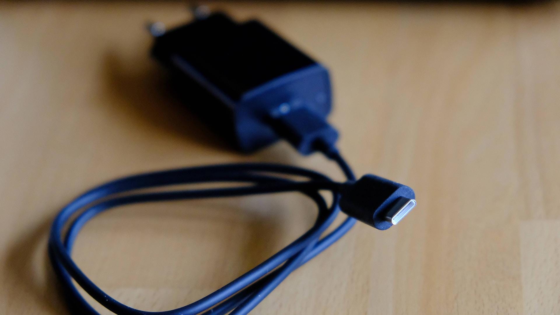 Ein USB-C-Kabel liegt aufgerollt auf einem Tisch: Mit dem neuen Standard können Geräte aufgeladen oder Daten übertragen werden. Ein USB-C-Kabel liegt aufgerollt auf einem Tisch: Mit dem neuen Standard können Geräte aufgeladen oder Daten übertragen werden.
