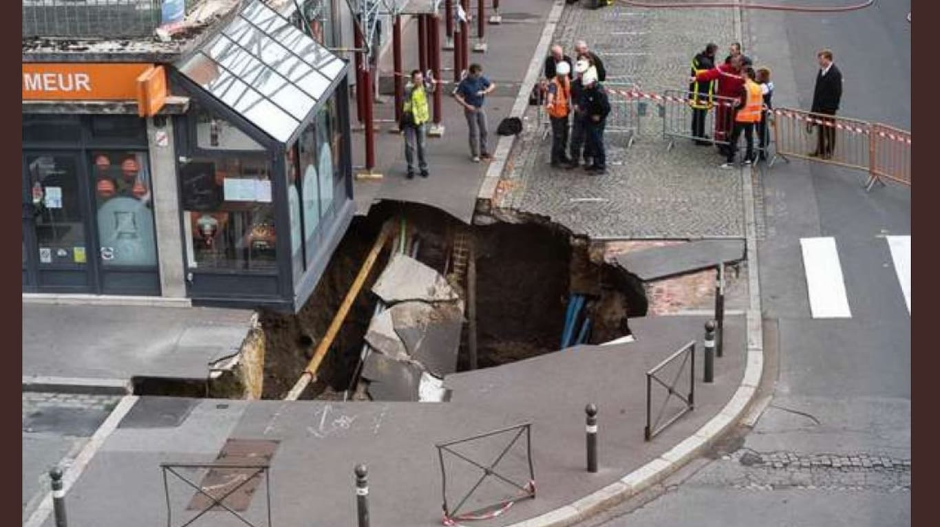 Feuerwehrleute und Bauarbeiter begutachten den Schaden in Amiens: Vor einem Restaurant hat sich ein zehn Meter breites Loch aufgetan.