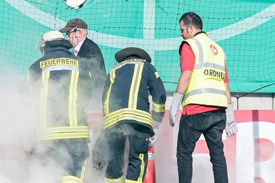 Feuerwehrleute löschen Bengalos aus dem Mainzer Fanblock.