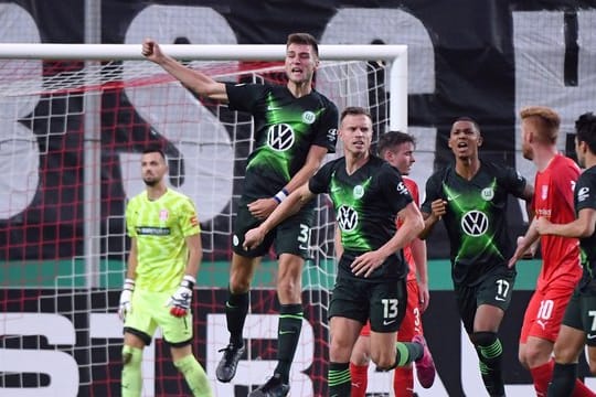 Halle-Keeper Kai Eisele (l-r) ist geschlagen, Wolfsburgs Robin Knoche feiert sein Tor zum 4:3.