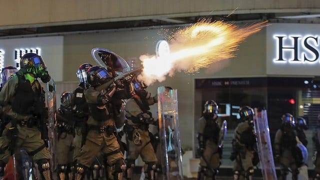 Polizisten feuern am Wochenende in Hongkong Tränengas auf Demonstranten. Polizisten feuern am Wochenende in Hongkong Tränengas auf Demonstranten.