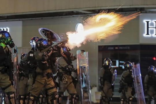 Polizisten feuern am Wochenende in Hongkong Tränengas auf Demonstranten.
