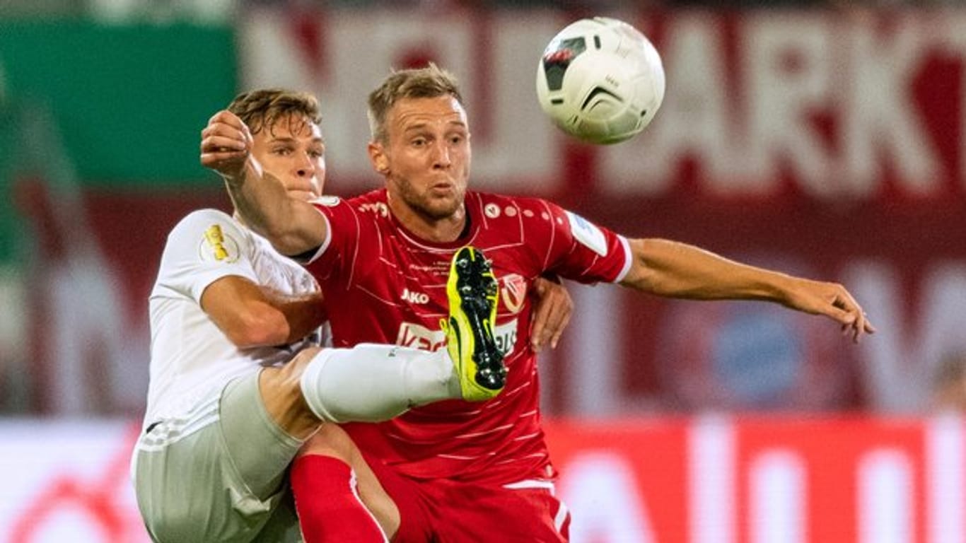 Voller Körpereinsatz: Bayern Münchens Joshua Kimmich (l) kämpft mit dem Cottbuser Felix Brügmann um den Ball.