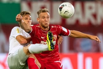 Voller Körpereinsatz: Bayern Münchens Joshua Kimmich (l) kämpft mit dem Cottbuser Felix Brügmann um den Ball.