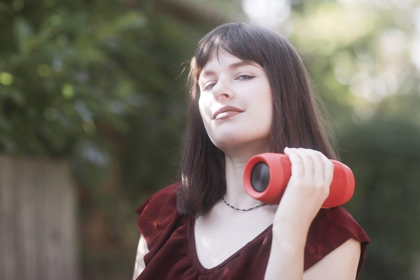 Eine junge Frau trägt einen Bluetooth-Lautsprecher auf der Schulter: Die kleinen Geräte machen richtig Krach. Immer mehr Bürger sind genervt.