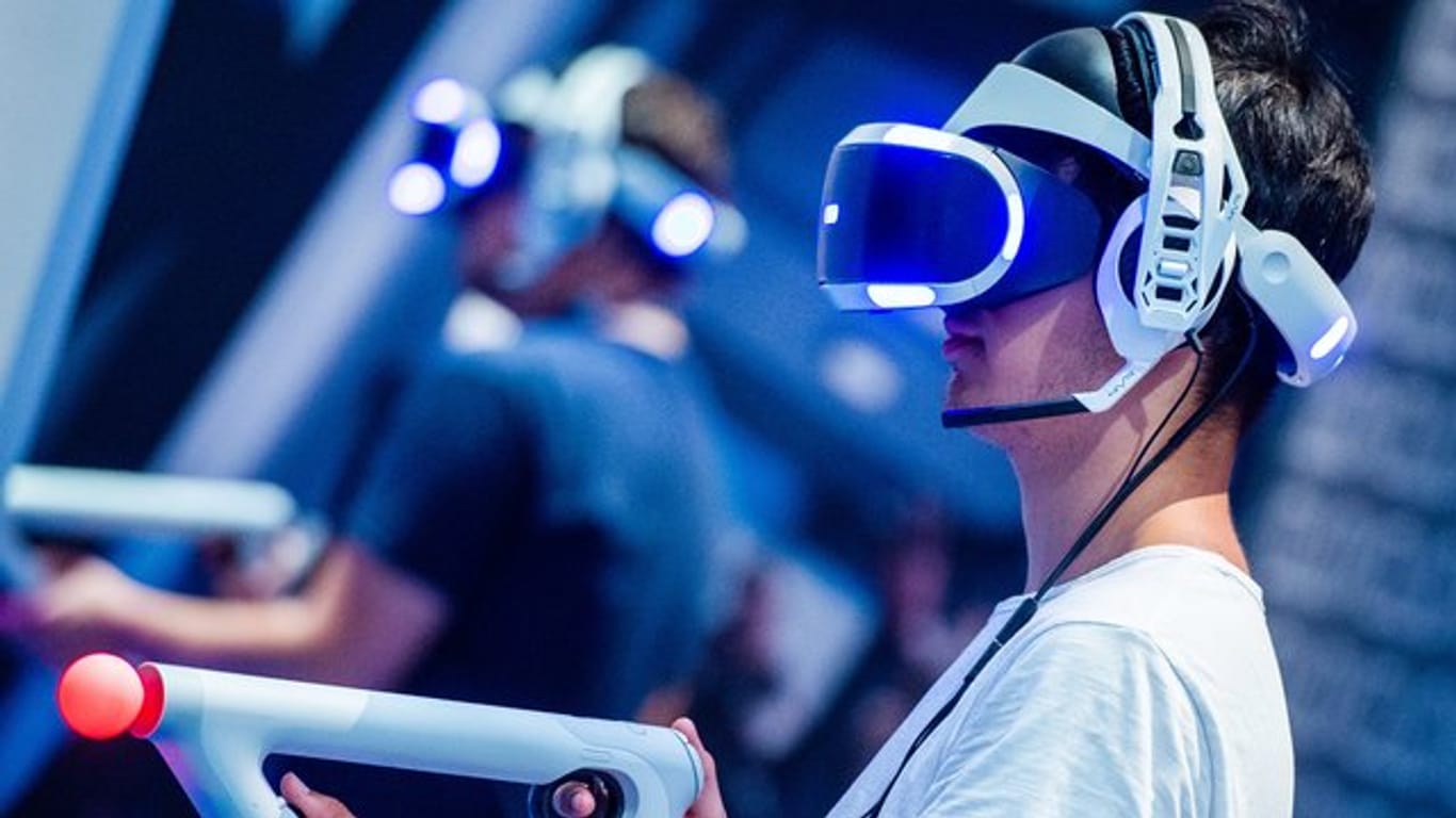 Ein Besucher der Kölner Gamescom probiert an einem Stand ein Videospiel mit einer VR-Brille aus.